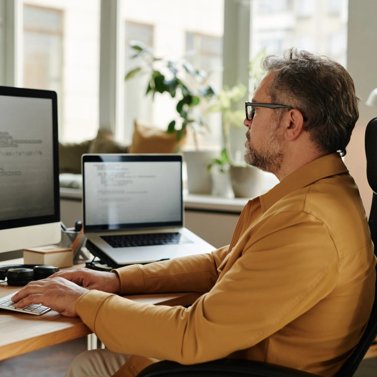 homem sentado na cadeira usando notebook